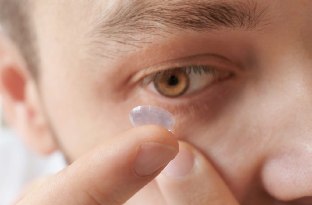 A man placing a daily contact lens into his eye