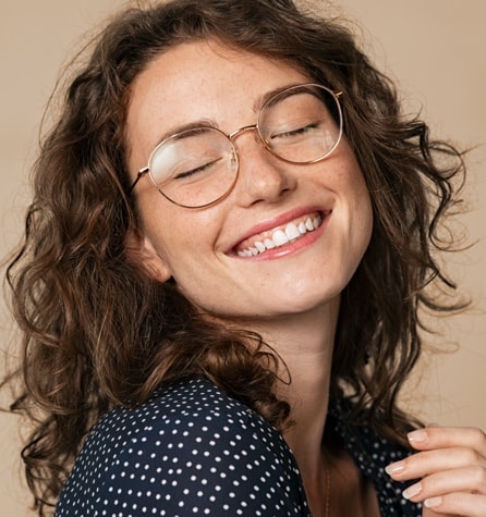 A young woman smiling and wearing glasses