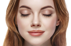 A woman with long eyelashes closing her eyes