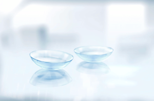 A pair of contact lenses on a reflective surface.
