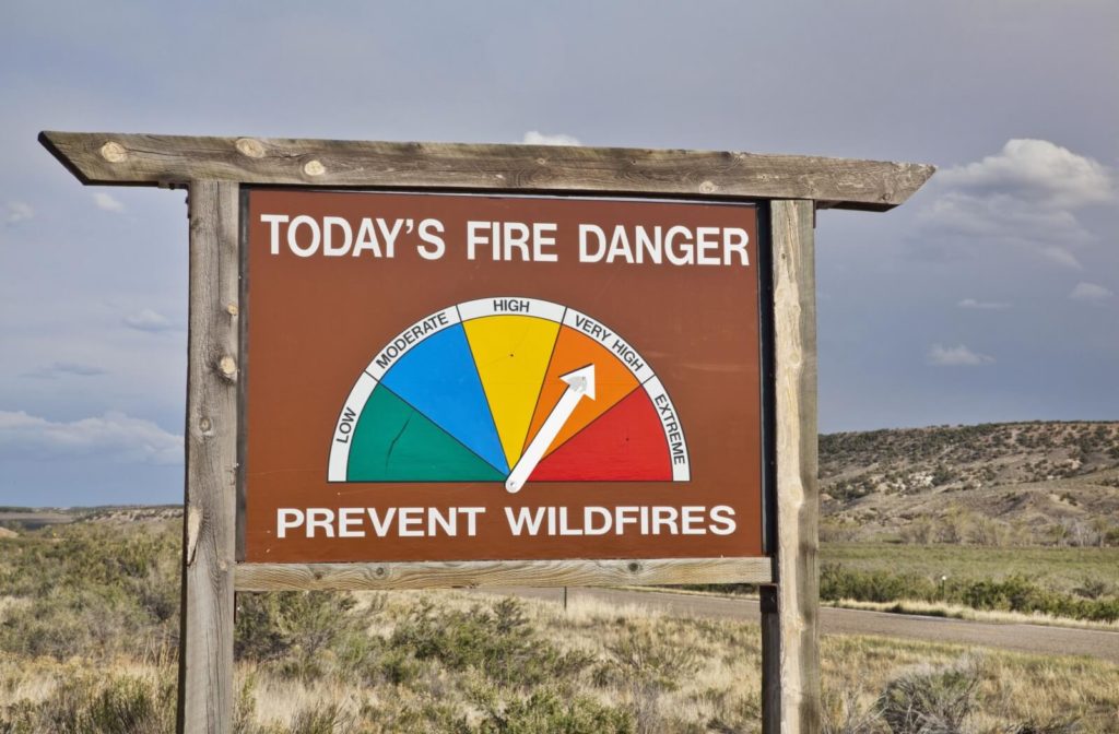 An image of a wildfire danger sign outdoors with the arrow pointing at "very high."