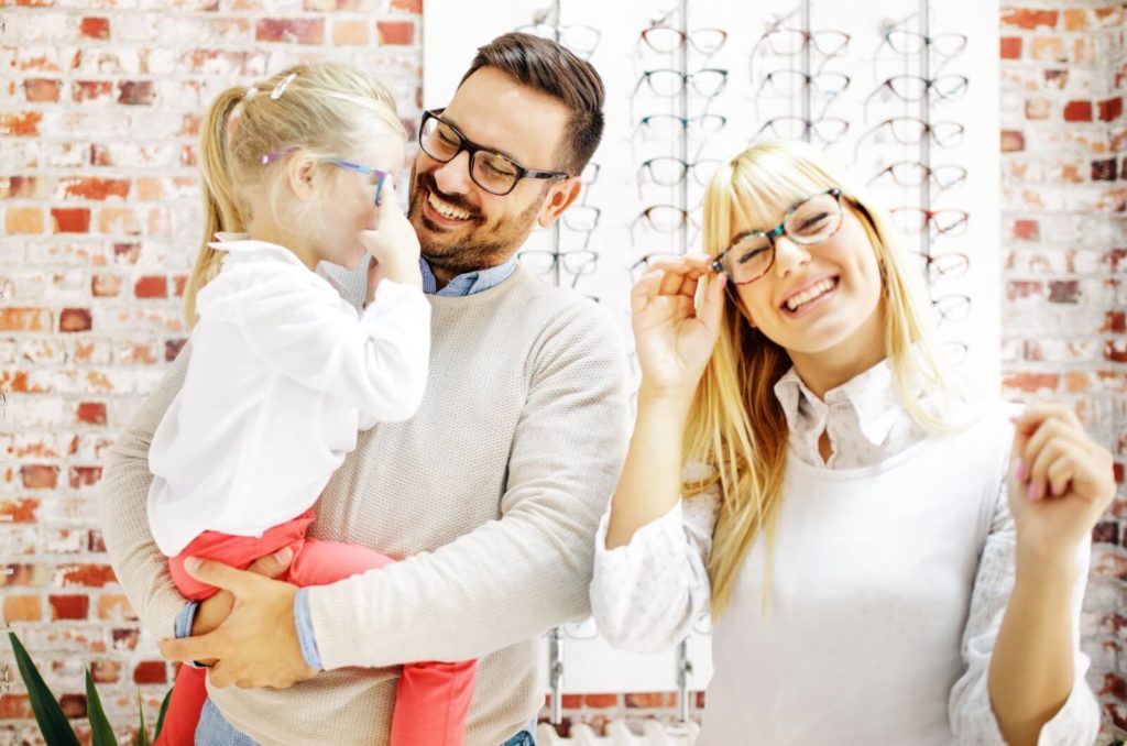 A young family of three browsing for their new eyeglasses.