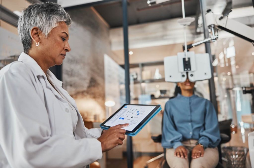 An optometrist assesses their patient's visual acuity during their routine eye exam.