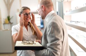 An optician helps someone find frames they like and that suit their face.